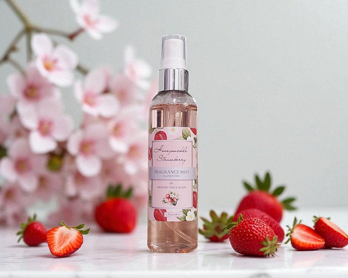 Bottle of Honeysuckle Strawberry Fragrance Mist with strawberries and cherry blossoms in the background