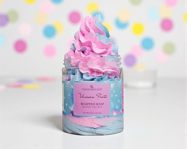 Jar of whipped soap with pink and blue colors against a colorful polka dot background