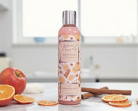 Body wash bottle with fruit and cinnamon on a table
