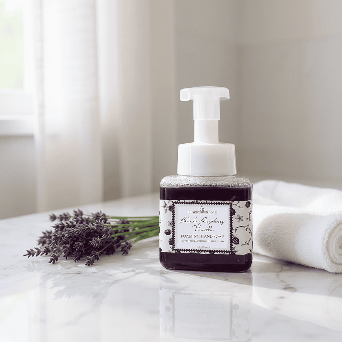 Foaming hand soap bottle with lavender on a marble surface