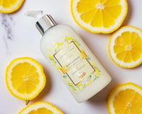 Body lotion bottle with lemon slices on a marble background