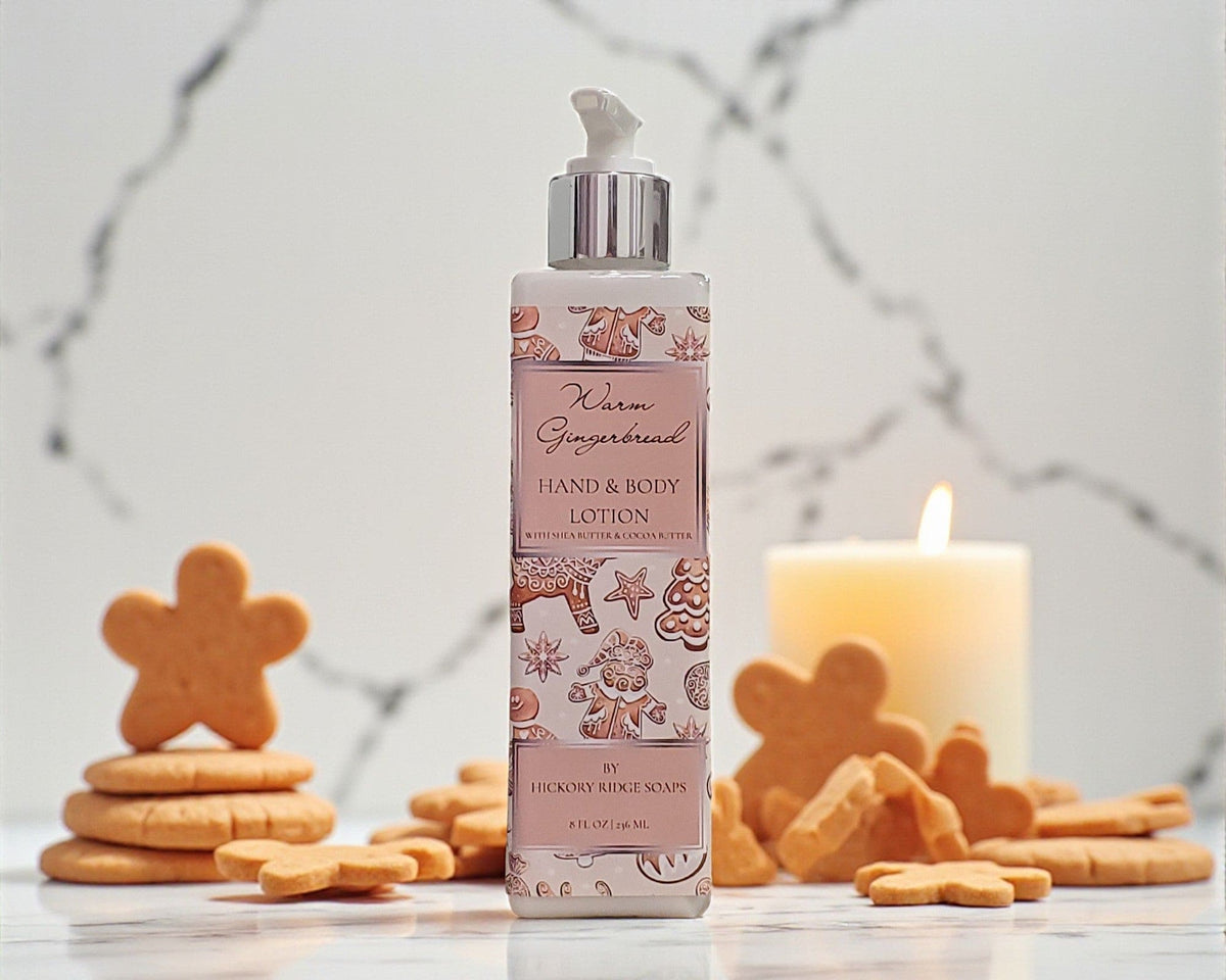 Hand and body lotion bottle with gingerbread theme on a surface with cookies and a candle.